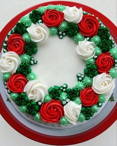 a cake decorated with red, white and green flowers