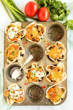 an overhead view of some taco shells with tomatoes and lettuce on the side