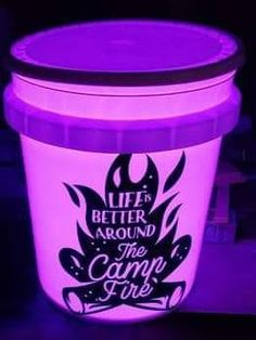 a lit up bucket with the words life is better around the campfire on it