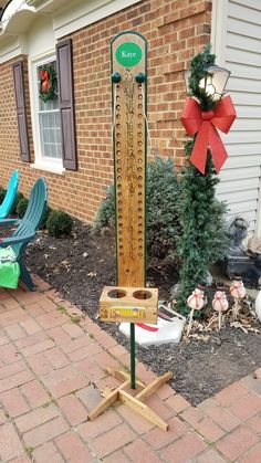 a wooden pole with a sign on it in front of a brick house and lawn chairs