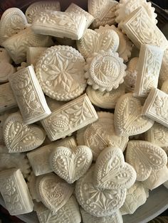 a bowl filled with lots of white heart shaped cookies