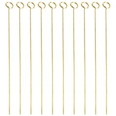 six gold colored metal picks on a white background