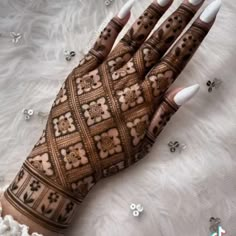 a woman's hands with hennap and white nails on top of it