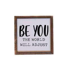 a sign that says be you the world will adjust on it's wall mounted frame