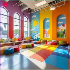 an indoor play area with colorful walls and flooring in the center, surrounded by large windows