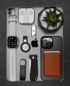 an assortment of electronics and gadgets laid out on a table with one apple watch