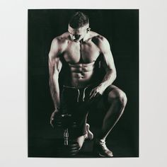 a shirtless man squatting down with his hands on the ground while holding a dumbbell