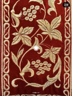 a red rug with white and gold designs on the front, along with a button in the middle