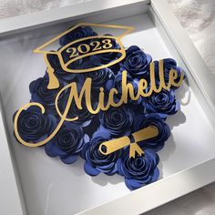 a white box with some blue flowers and a graduation cap