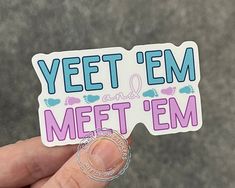 someone holding up a sticker that says yet'em and met'em