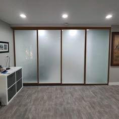 an empty room with frosted glass walls and grey flooring is pictured in this image