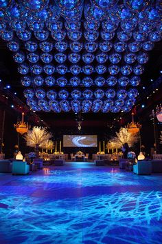 a large room with blue lights and chandeliers