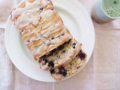 two slices of blueberry bread on a plate next to a cup of green tea