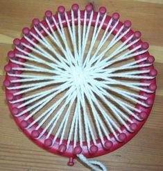 a red and white toy fan sitting on top of a wooden floor next to a string