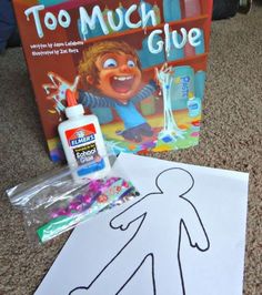 the children's book and glue are sitting on the floor next to their drawing