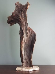 a piece of wood sitting on top of a wooden table next to a gray wall