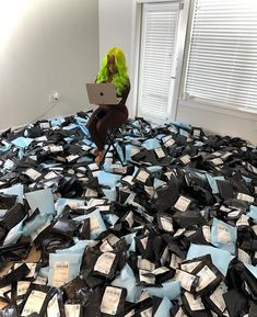 a woman sitting on top of a pile of black and blue boxes