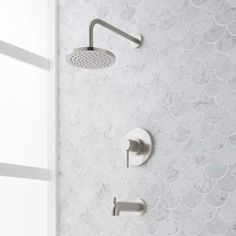 the shower head and hand shower faucet are shown in this bathroom with white marble