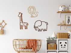 a baby's room decorated in white and gold with animal wall art on the walls