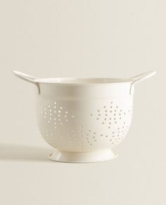 a white colander sitting on top of a table