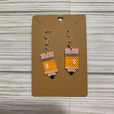 a pair of earrings that are made out of legos and some sort of paper