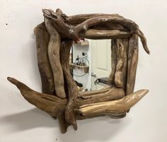 a mirror made out of driftwood is hanging on the wall