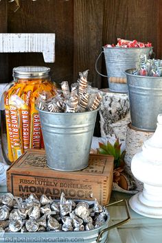 several buckets filled with candy sitting on top of a table next to other items