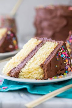 a slice of cake with chocolate frosting and sprinkles on a plate