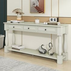 a white console table with two drawers and shoes on the bottom shelf next to it