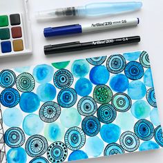 an artist's notebook with watercolors and markers