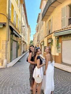 three girls standing in the middle of an alley way