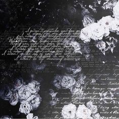 white flowers on black paper with writing in the background