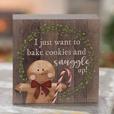 a wooden sign with a gingerbread on it that says i just want to bake cookies and snuggle up