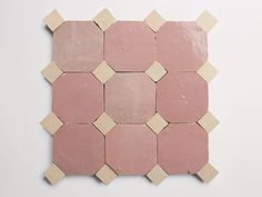 a pink and beige mosaic tile on a white wall