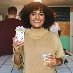 a woman holding a gift box and smiling at the camera