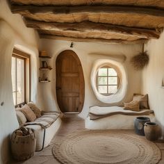 a living room filled with lots of furniture next to a round window on the wall