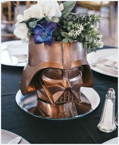 a star wars themed centerpiece with flowers in the shape of darth vader's helmet