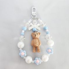 a keychain with a teddy bear on it's side and beads around it