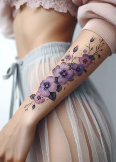 a woman's arm with purple flowers on the left side of her body and tattoos on it