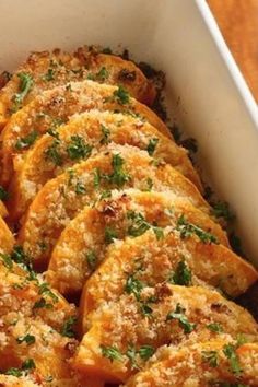 a casserole dish with bread and parmesan toppings in a white baking dish