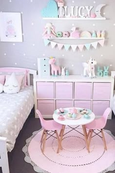 a room with two beds, pink chairs and a small table in the middle of it