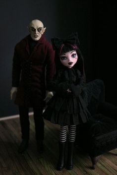 two creepy dolls standing next to each other