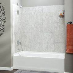 a white bath tub sitting inside of a bathroom next to a shower curtain and rug