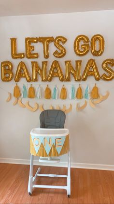 a baby's first birthday party with balloons and decorations, including an elephant chair