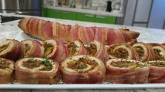 bacon wrapped sandwiches on a white platter