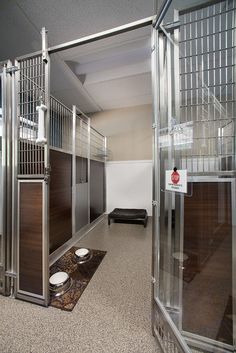 an empty room with metal partitions on the walls and doors to other rooms in it