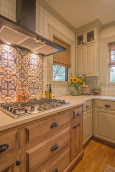 a stove top oven sitting inside of a kitchen next to a counter with flowers on it