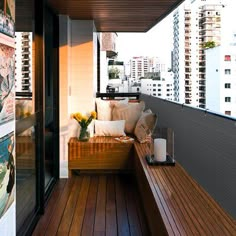 a wooden bench sitting on top of a balcony next to a tall building with lots of windows