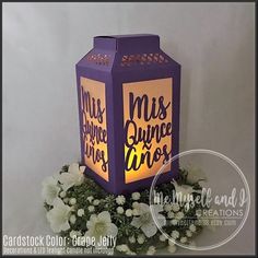 a purple lantern with the words miss and mr on it sitting next to some white flowers