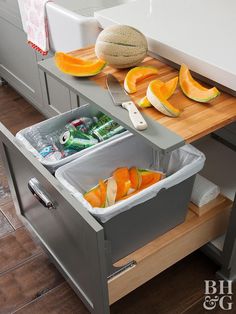 a kitchen counter with two bins filled with fruit